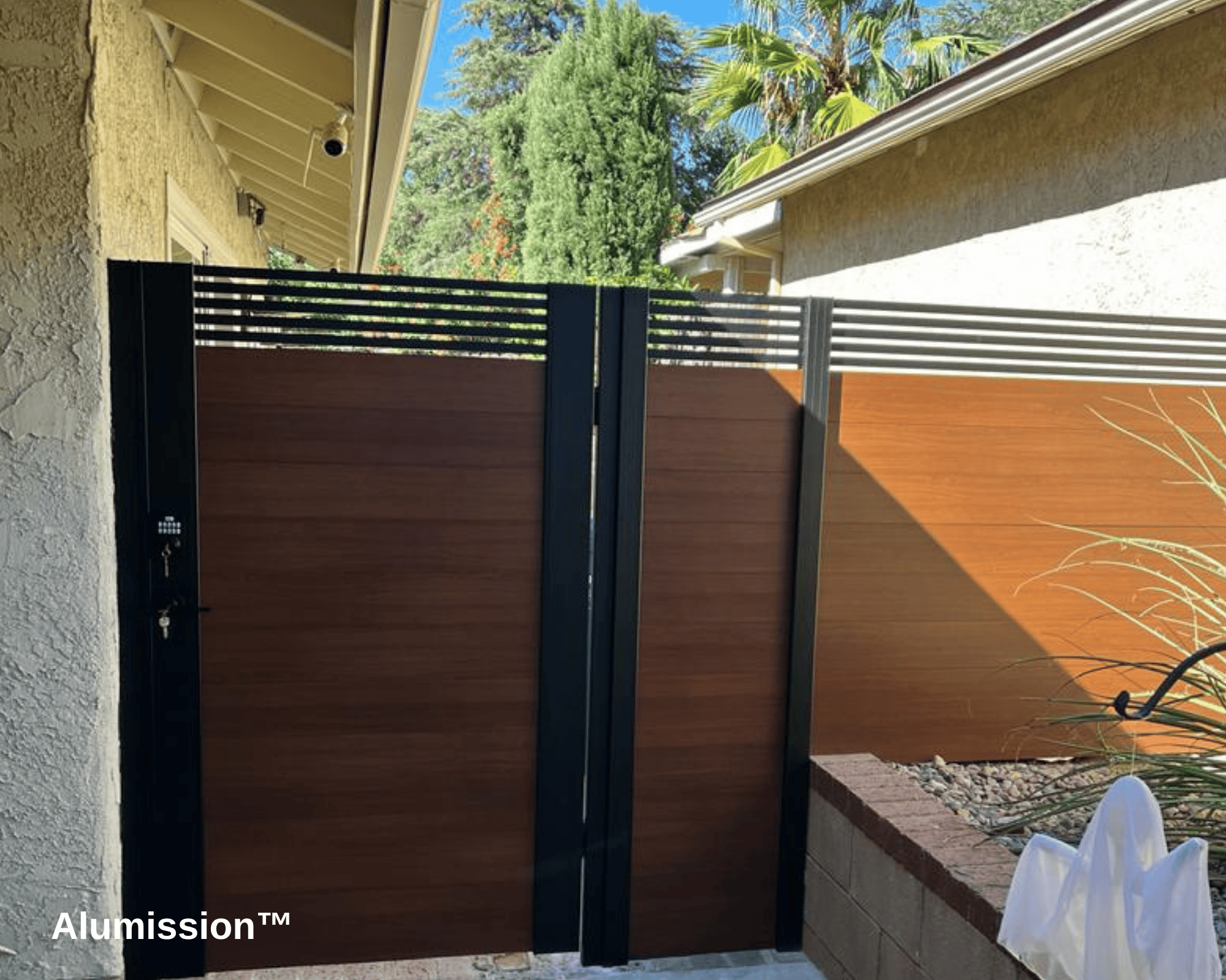 An aluminum fence and gate, painted brown to look like wood.