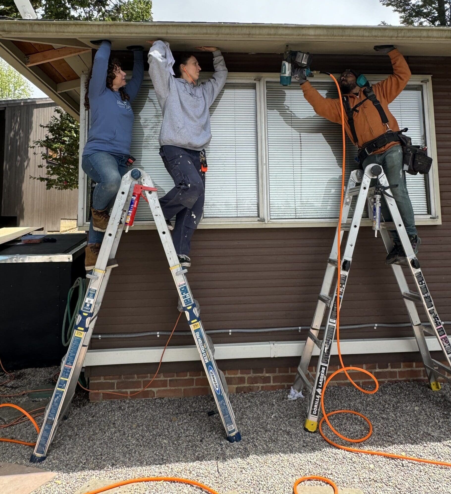 three people working on a house