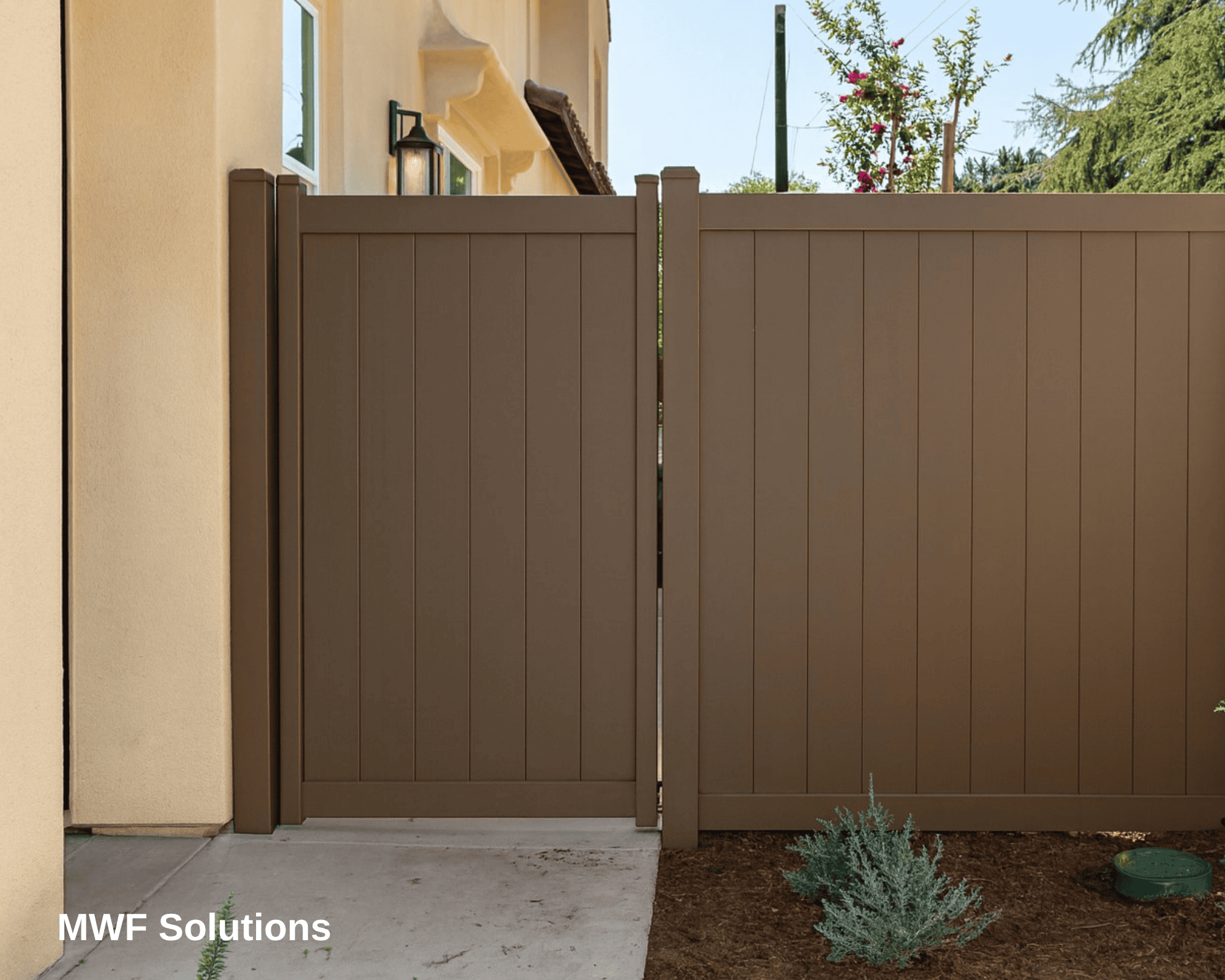A steel fence with a gate, painted to look like wooden boards.