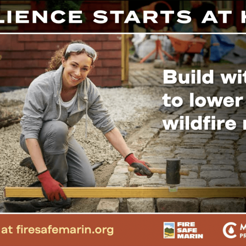 Photo of a woman laying pavers on a pathway using a mallet.