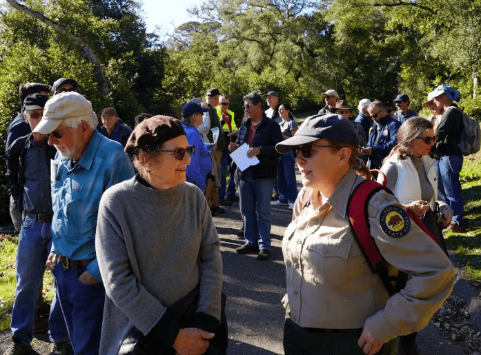 A crowd of field trip attendees, with two women in the foreground conversing.