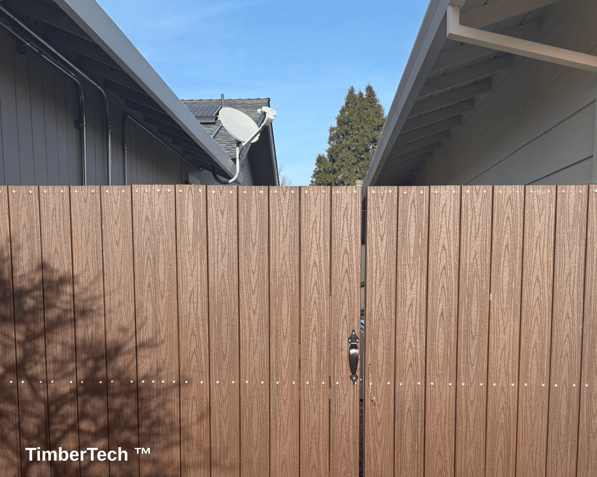 A front-facing brown fiber cement fence with a gate in the center.
