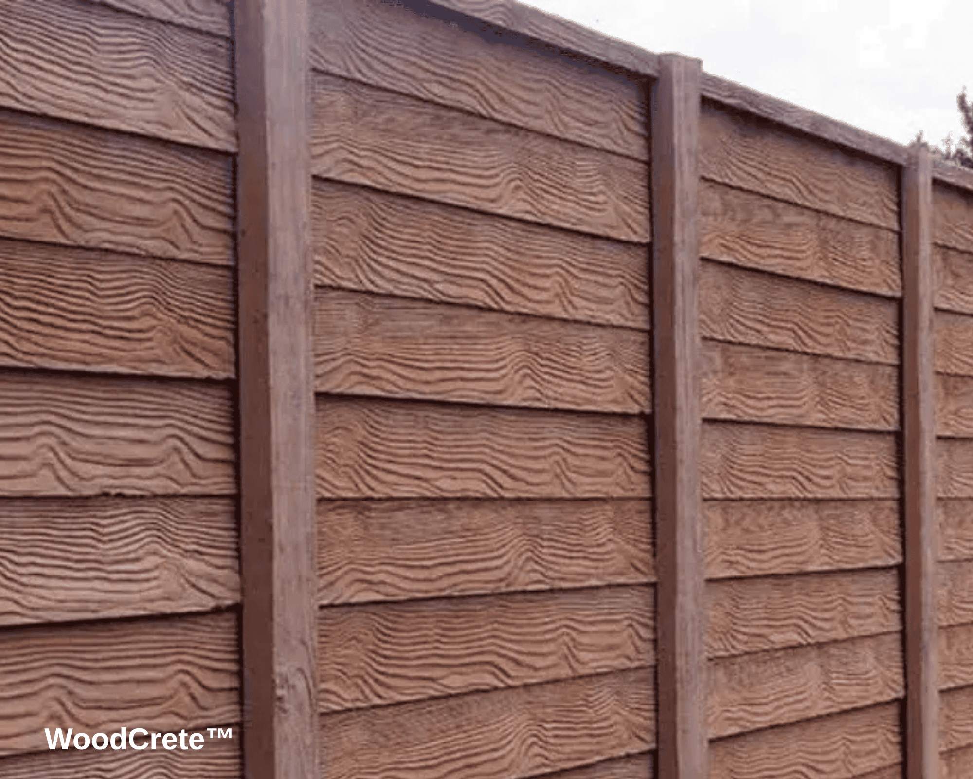A close-up of a brown slated fence made out of fiber cement to resemble the look of painted wood.