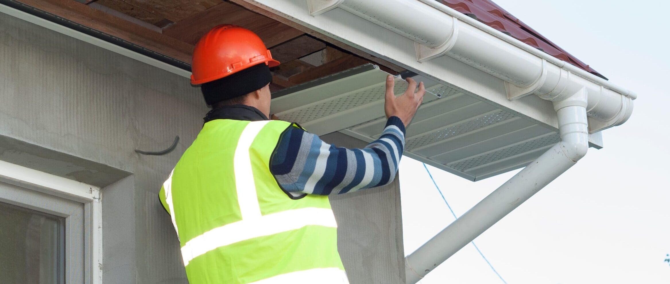 Construction,Worker,Mounts,A,Soffit,On,The,Roof,Eaves
