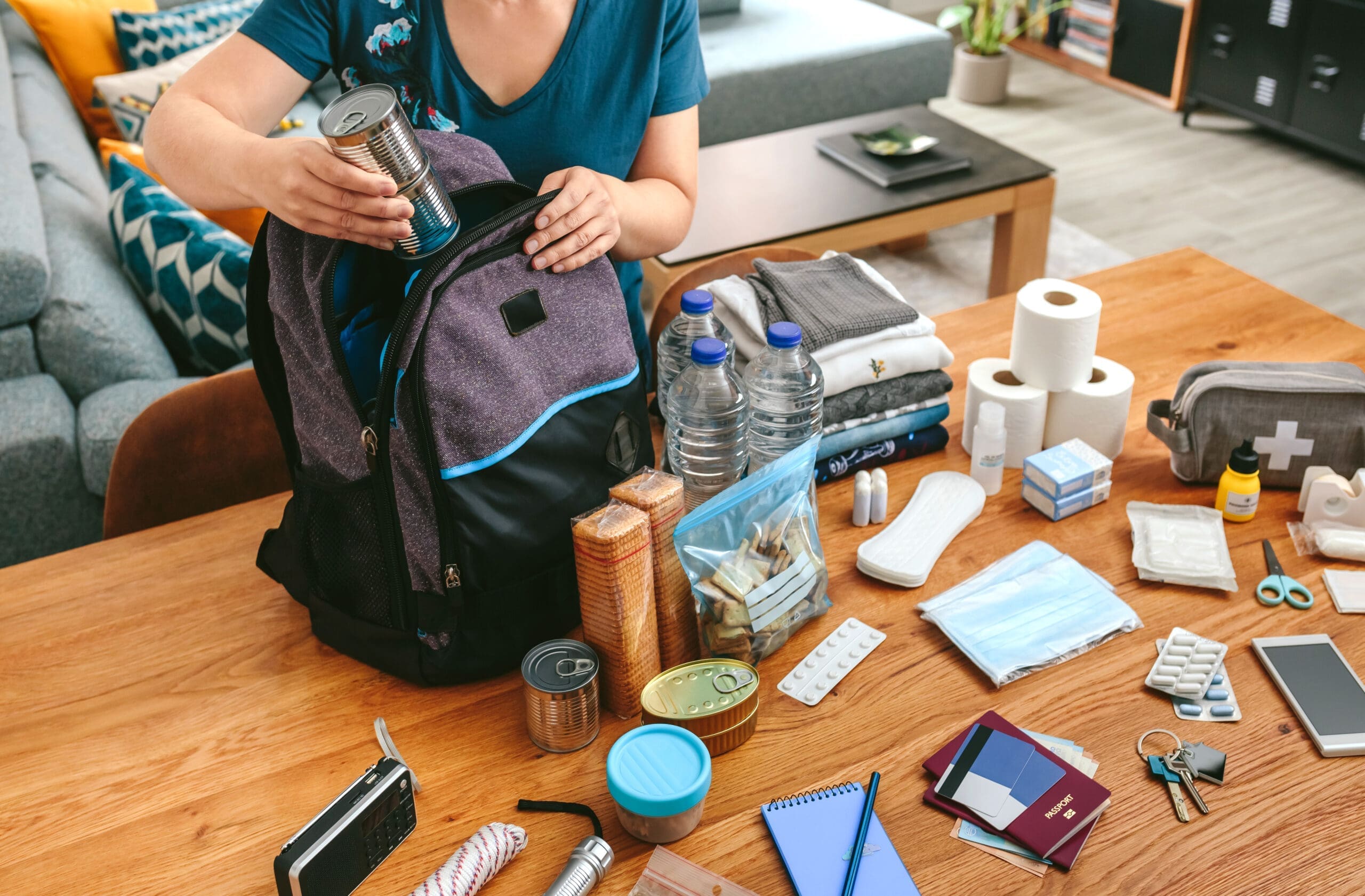 Unrecognizable,Woman,Putting,Cans,Of,Food,To,Prepare,Emergency,Backpack