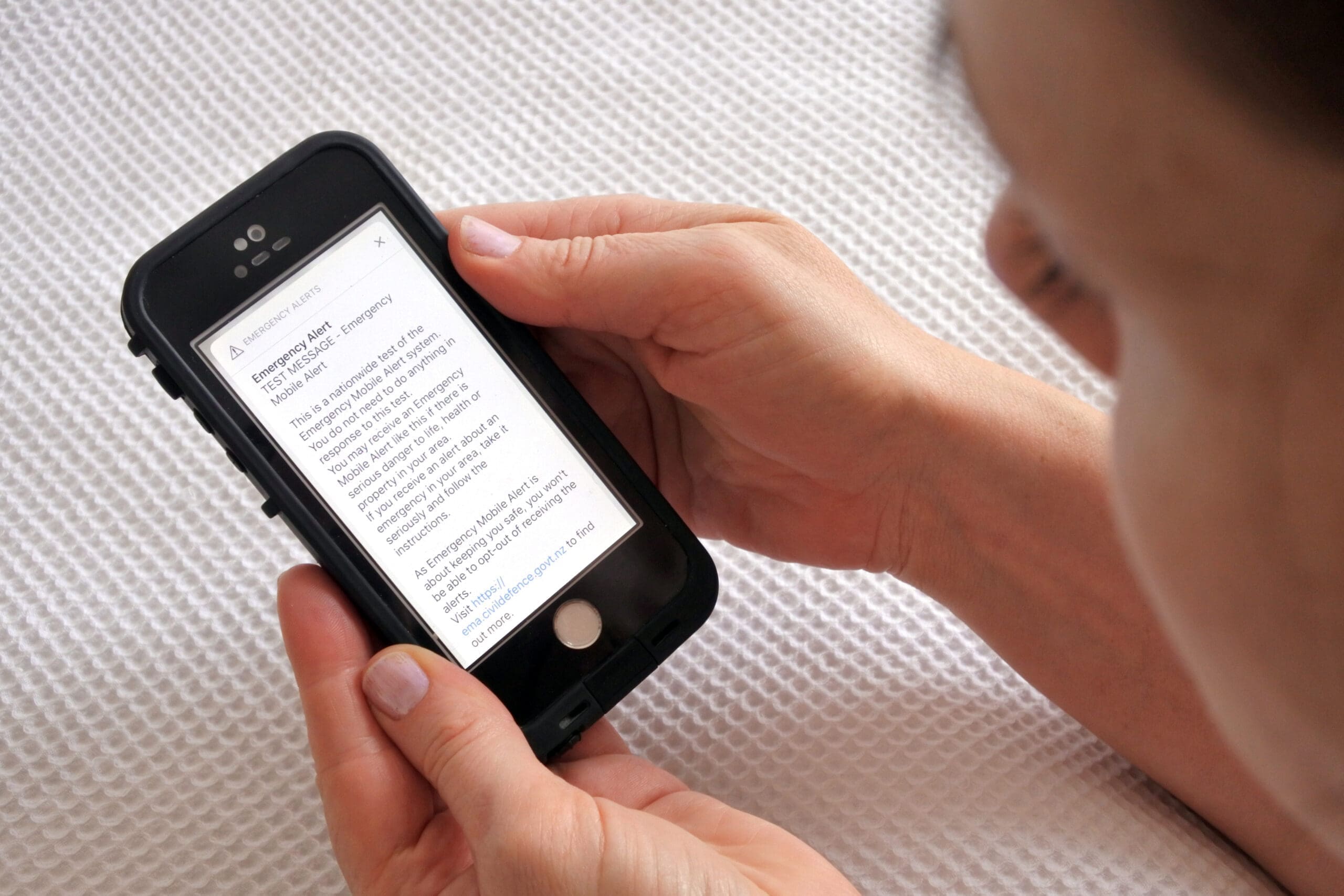 person reading an emergency text message