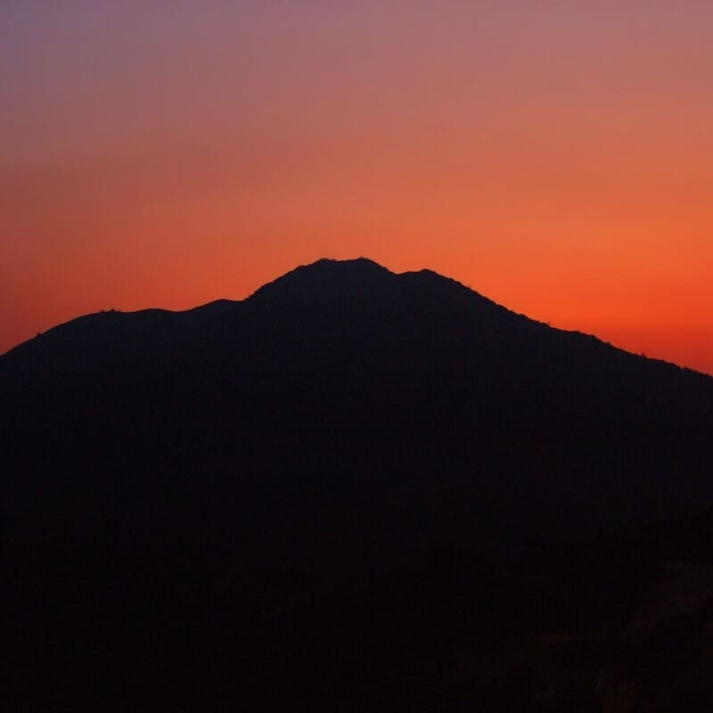 Silhouette of a mountain against a red sunset